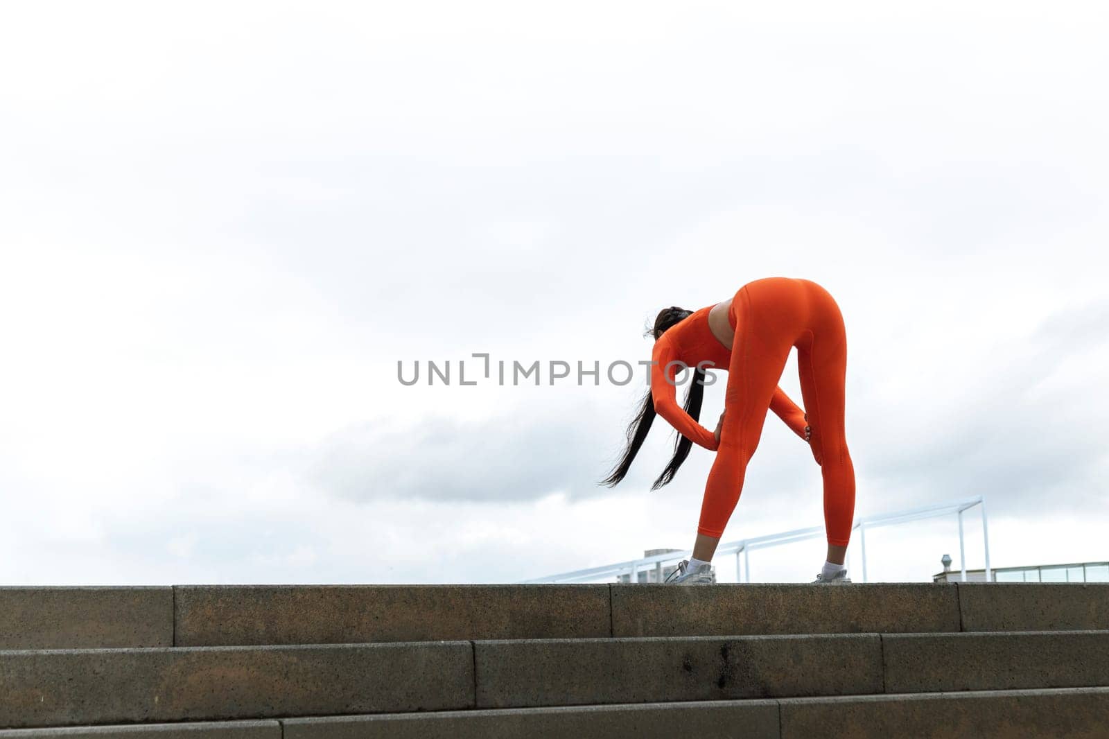 Young woman tired after running. Female athlete bending over catching her breath jogging. Sport concept. Active healthy lifestyle concept. Copy space.