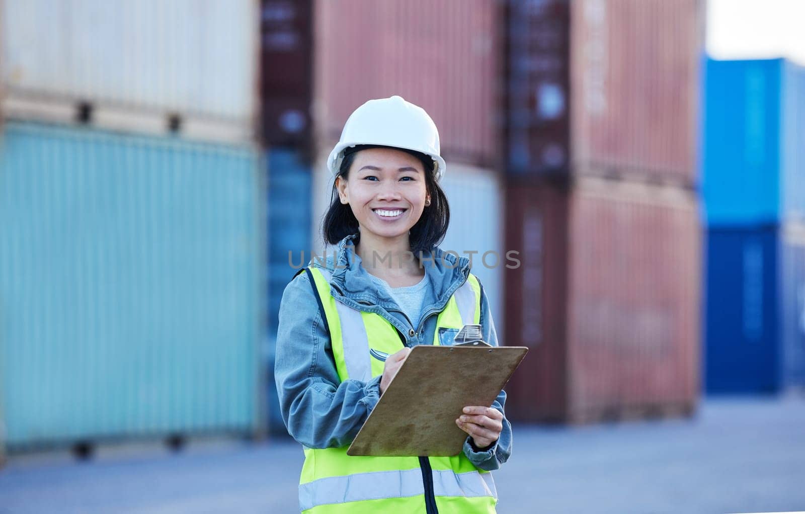 Woman with clipboard, shipping and logistics check of stock at work site. Asian worker in transportation industry, smile in portrait with container in background and safety inspection of product