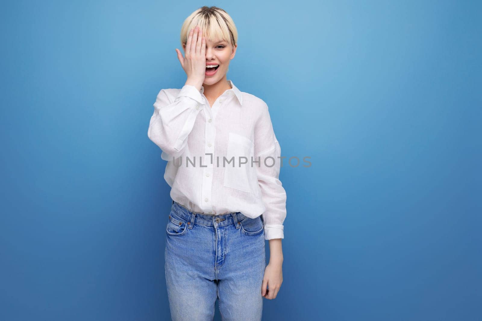 young caucasian woman with a short haircut is dressed in a white shirt on background with copy space. people lifestyle concept.