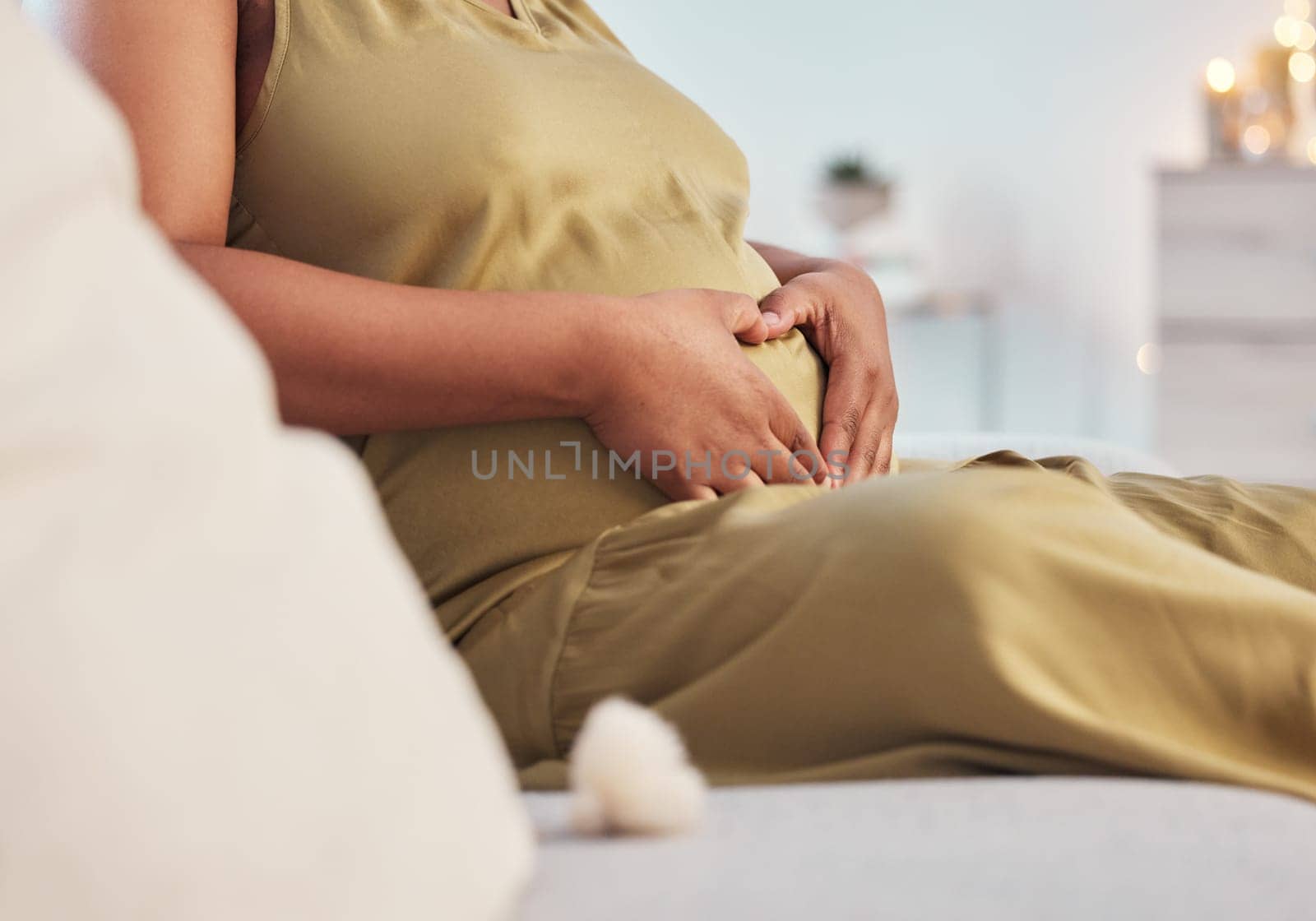 Pregnant stomach, couch and black woman hands with heart hand sign feeling mother love. Mom care, sofa and living room lounge with a person holding abdomen happy about pregnancy and baby in a house.