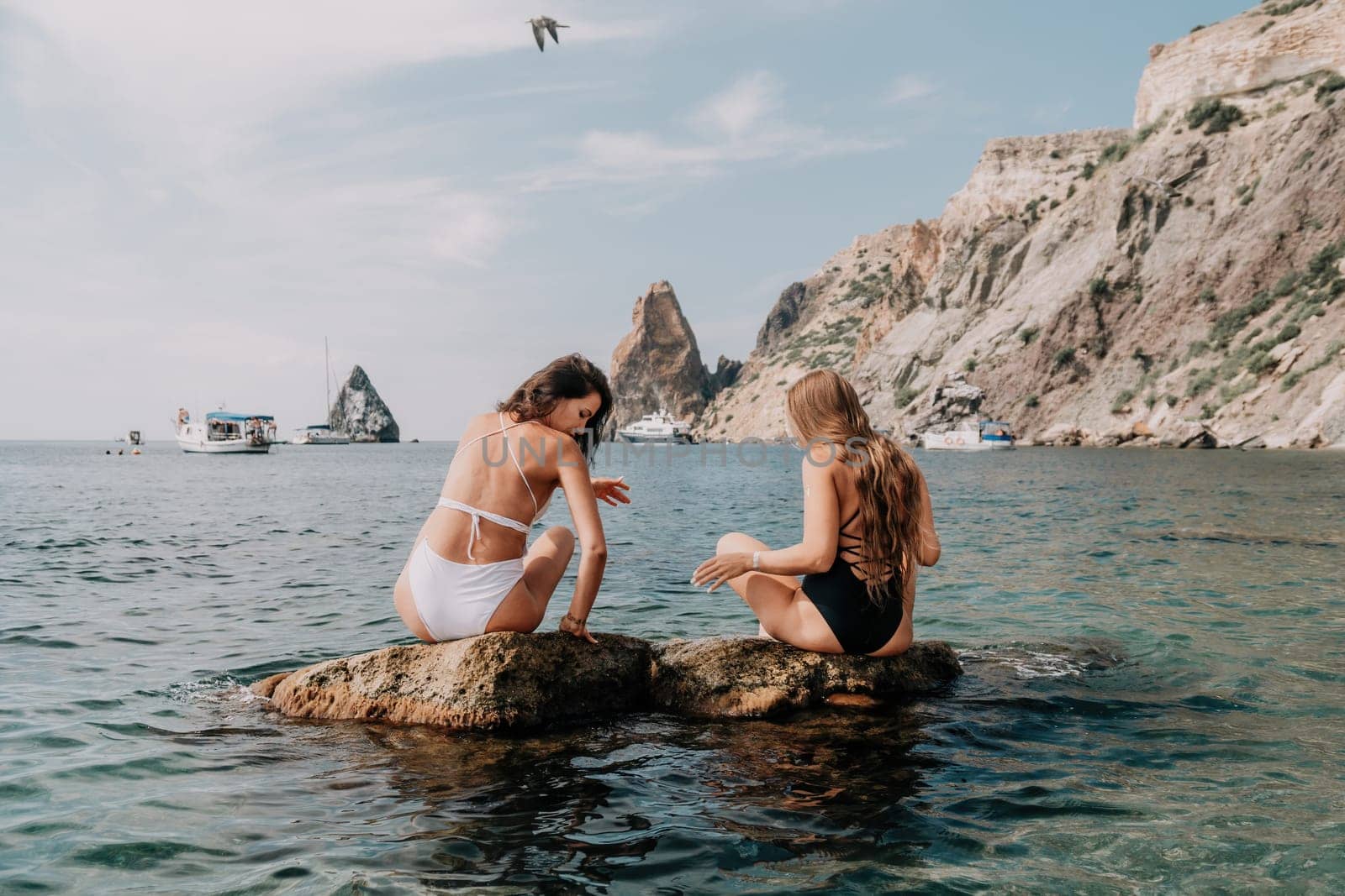 Woman sea yoga. Back view of free calm happy satisfied woman with long hair standing on top rock with yoga position against of sky by the sea. Healthy lifestyle outdoors in nature, fitness concept.