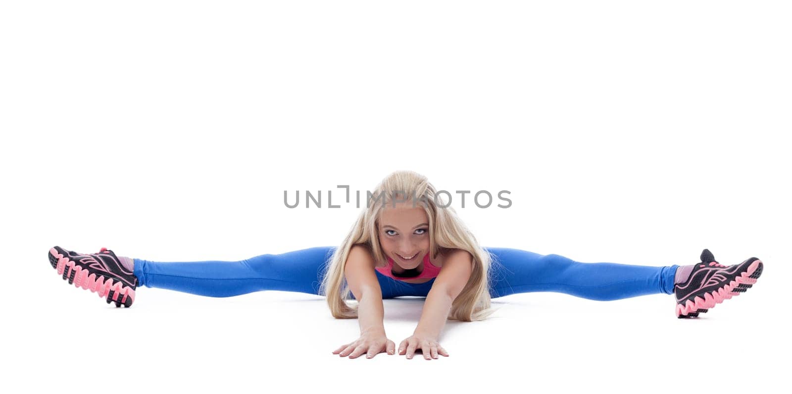 Image of energetic young woman posing on split in studio