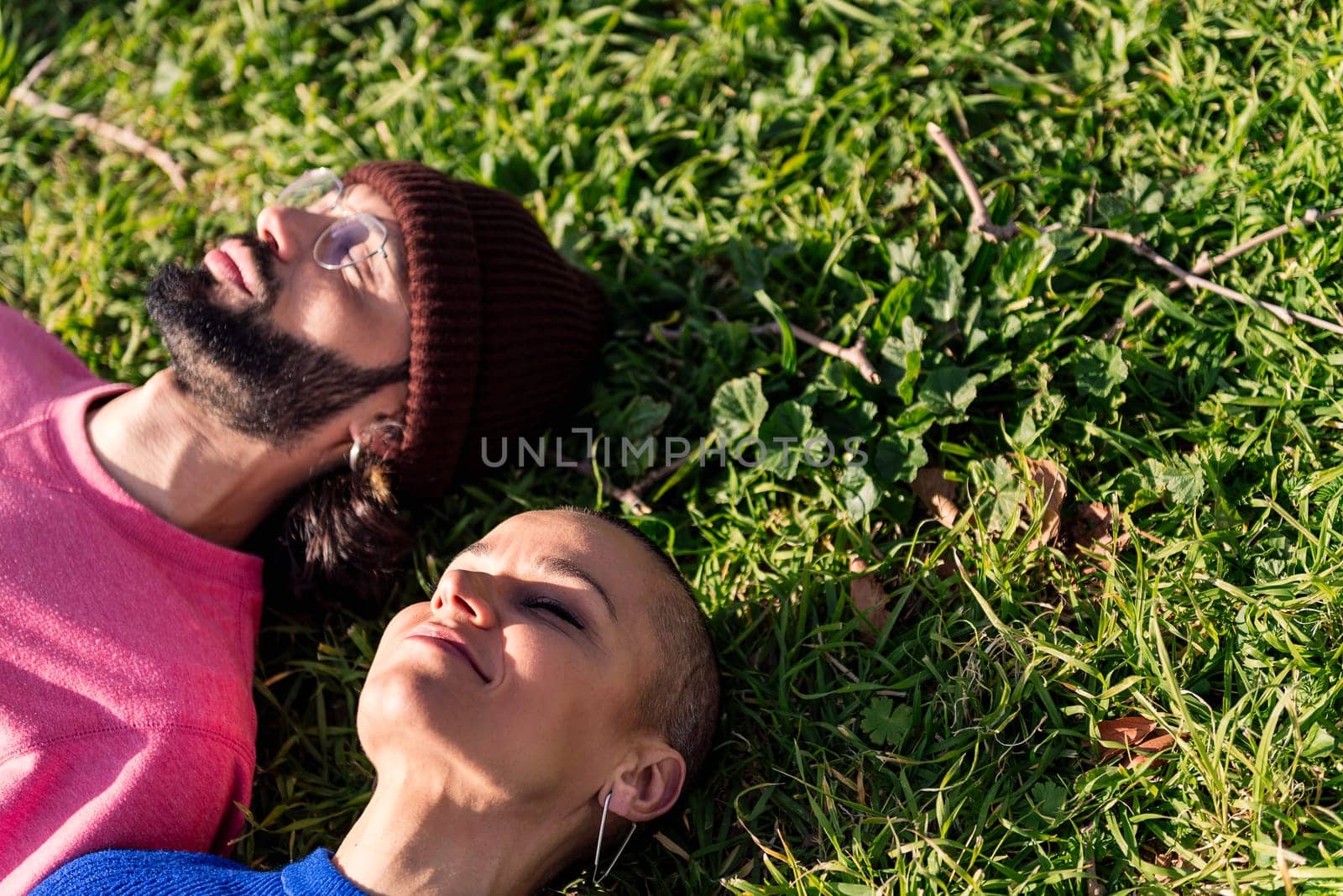 man and woman enjoying lazy day lying in the lawn by raulmelldo