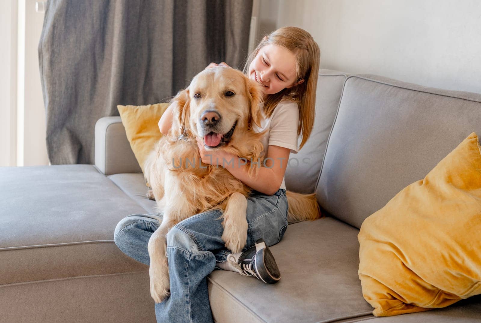 Preteen girl with golden retriever dog at home by tan4ikk1