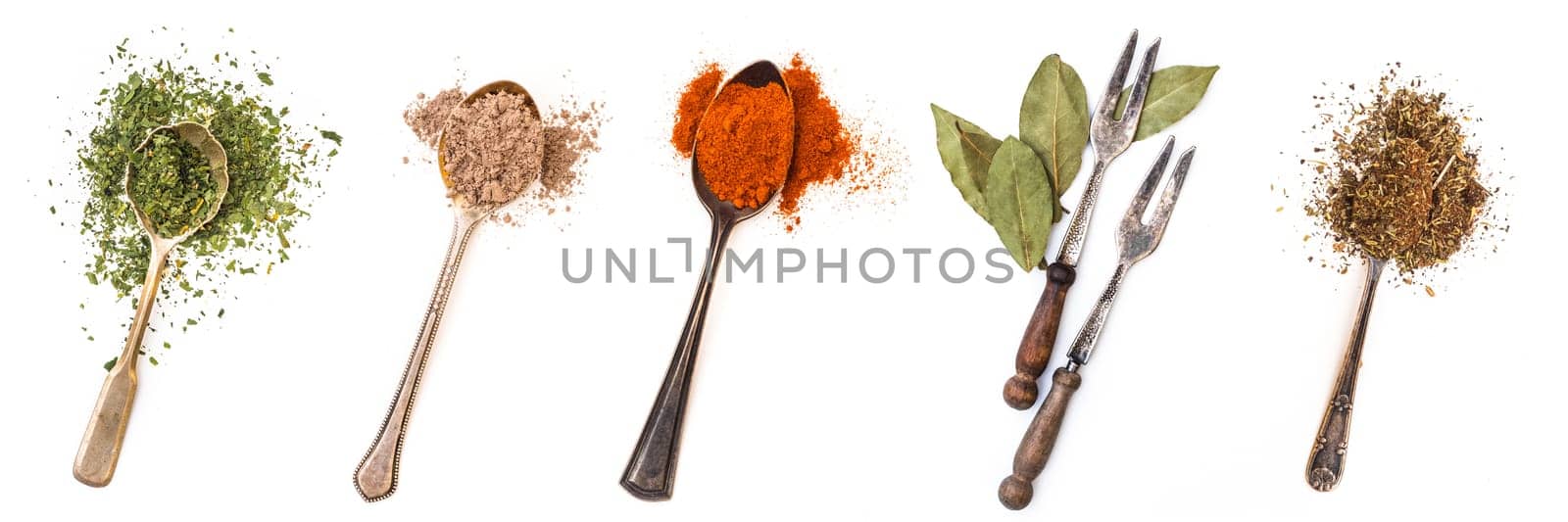 Different spices in retro spoons isolated on a white background