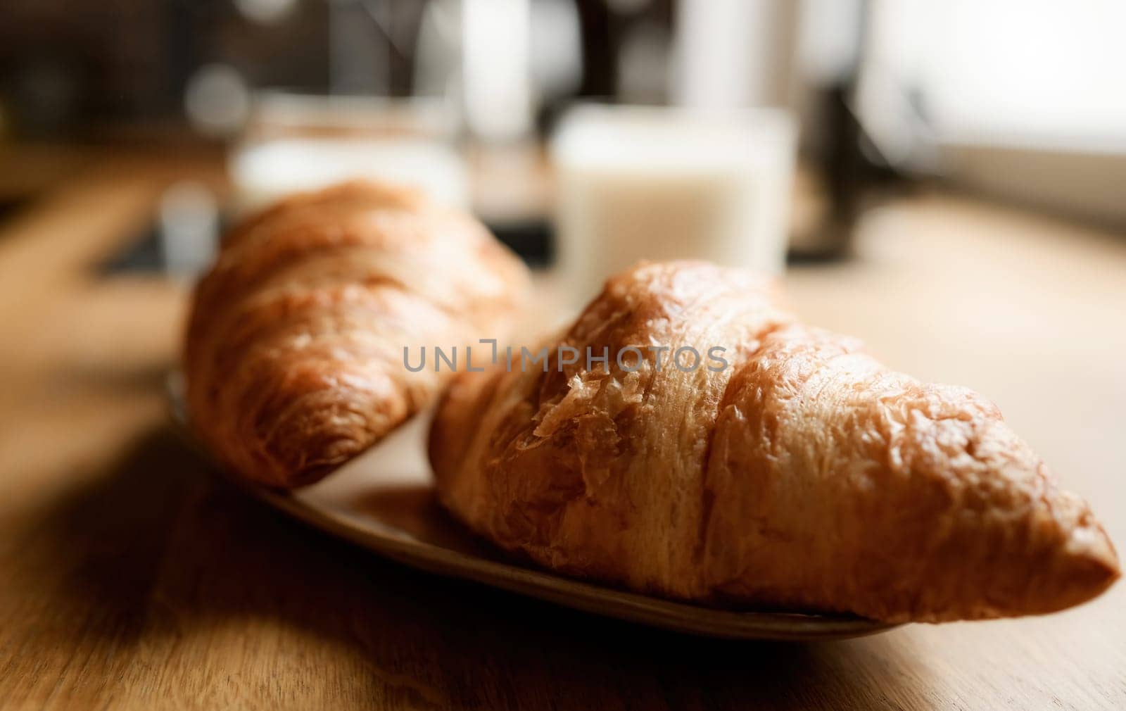 Two fresh croissants on a kitchen table. French breakfast