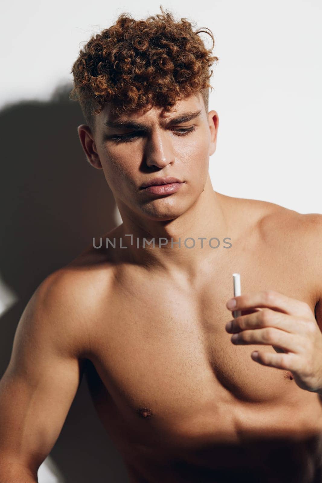 man smile attractive naked athlete white background adult smokes person health young muscular background strong chest gray abs handsome athletic bodybuilder studio