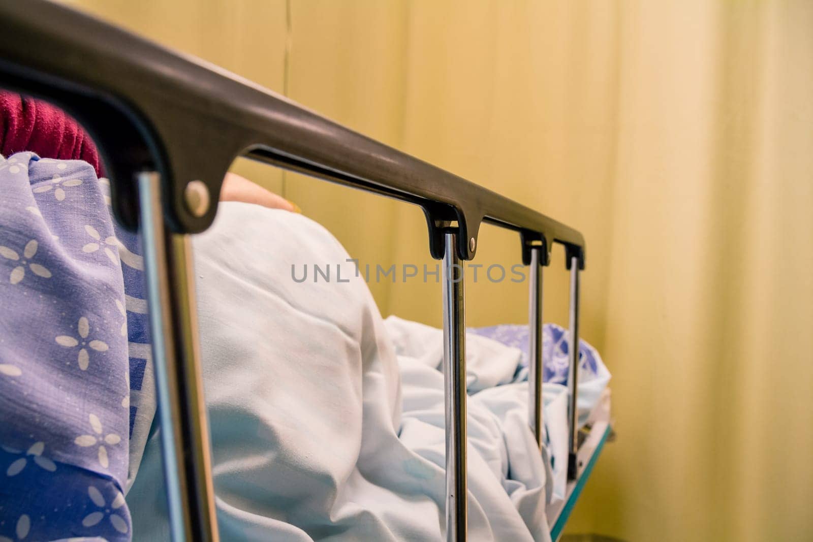 Woman patient lying on a bed in a hospital room.