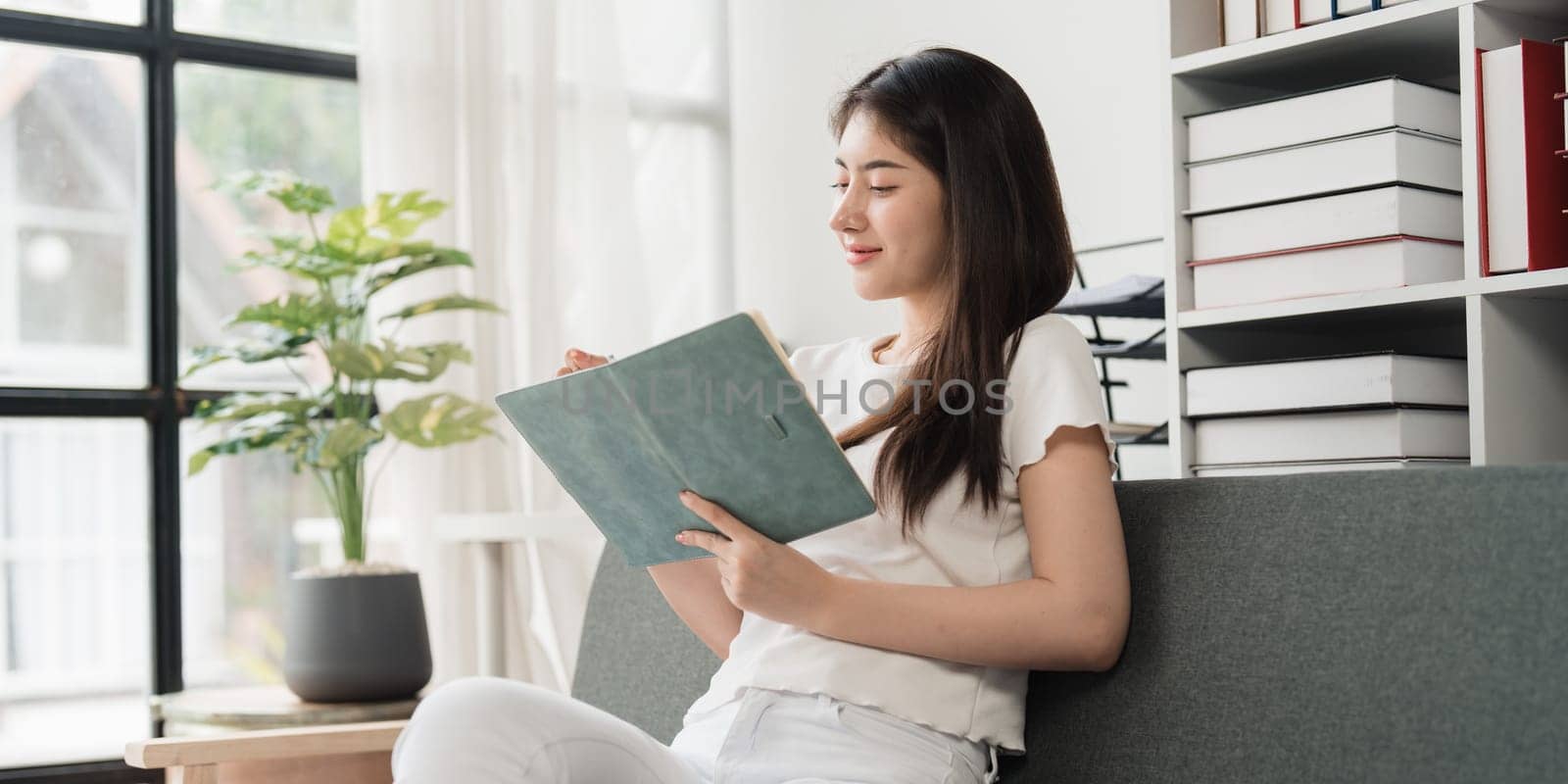 Attractive Asian woman resting comfortable living room and reading book, Relax, Sofa, Lifestyle.