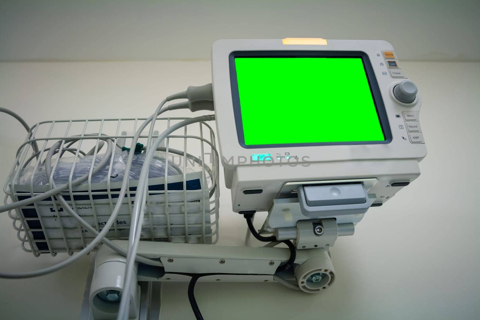 Medical monitor inside patient hospital room. Electrocardiograph in ward room. Mock up screen.