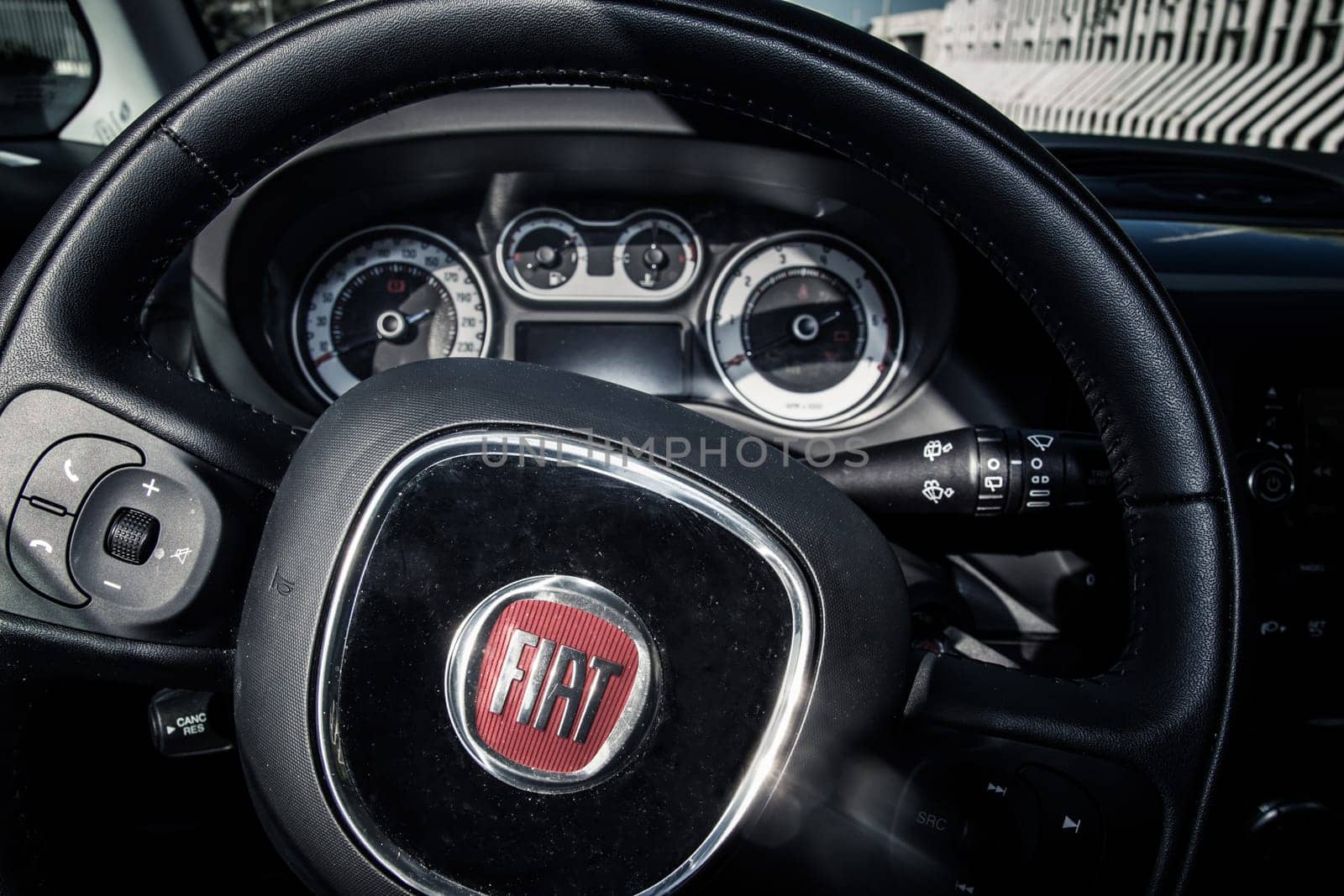 Alberobello, Italy - August 2, 2014: Close up of steering wheel and dashboard inside of a private car model Fiat 500L.
