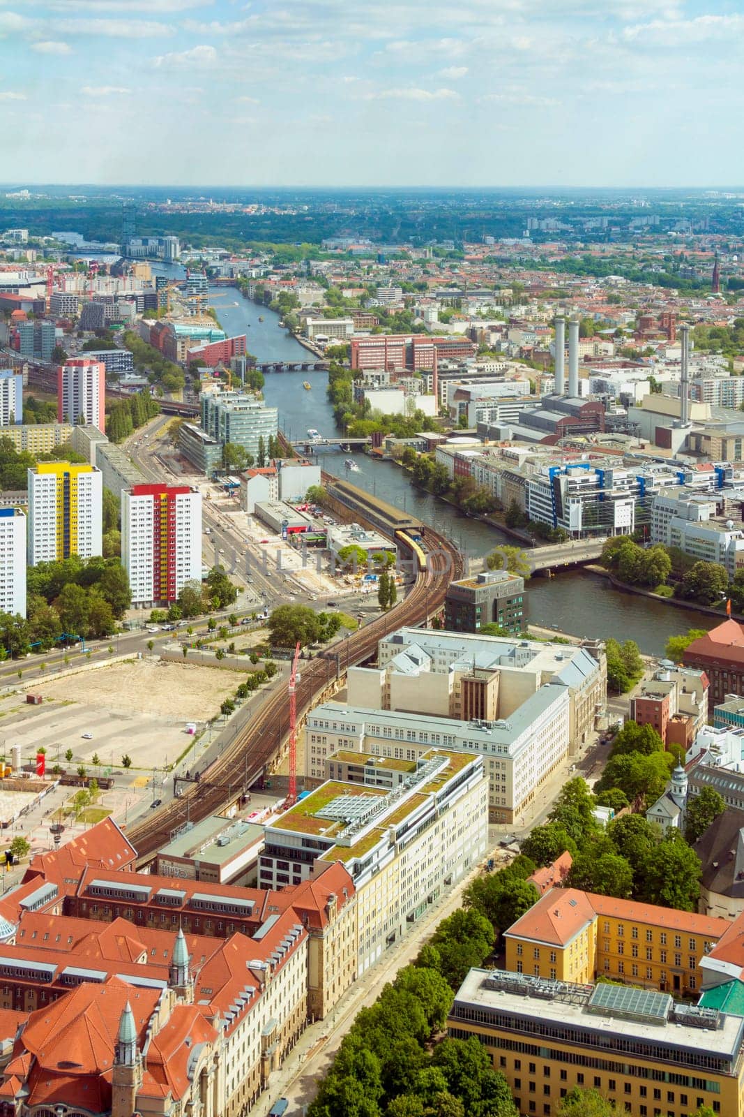 Aerial view of Berlin skyline with S-Bahn tracks rapid train and colorful buildings.