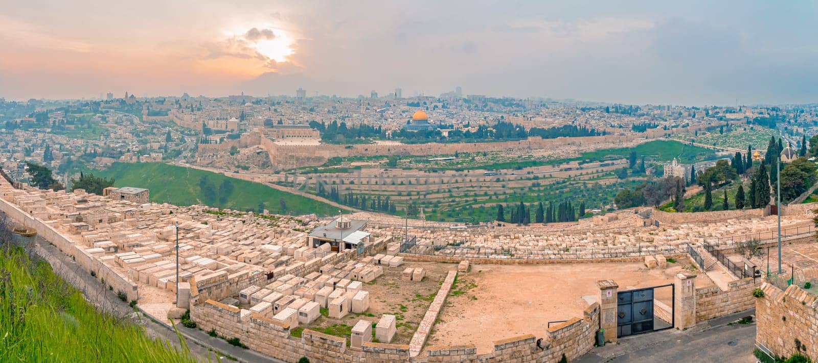 Panoramic view of Jerusalem old city and the Temple Mount during a dramatic colorful sunset. A view of the Tomb of the Prophets, Dome of the Rock and Al Aqsa Mosque from the Mount of Olives in Jerusalem, Israel.