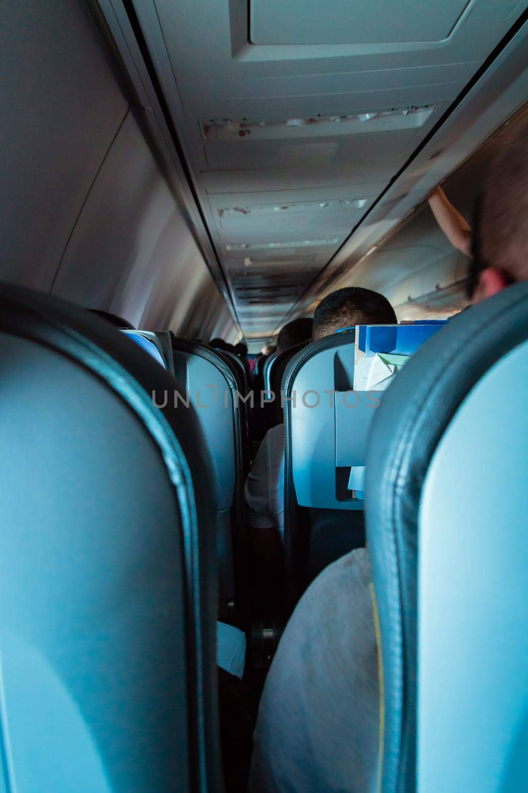 Interior of passenger airplane with people on seats.