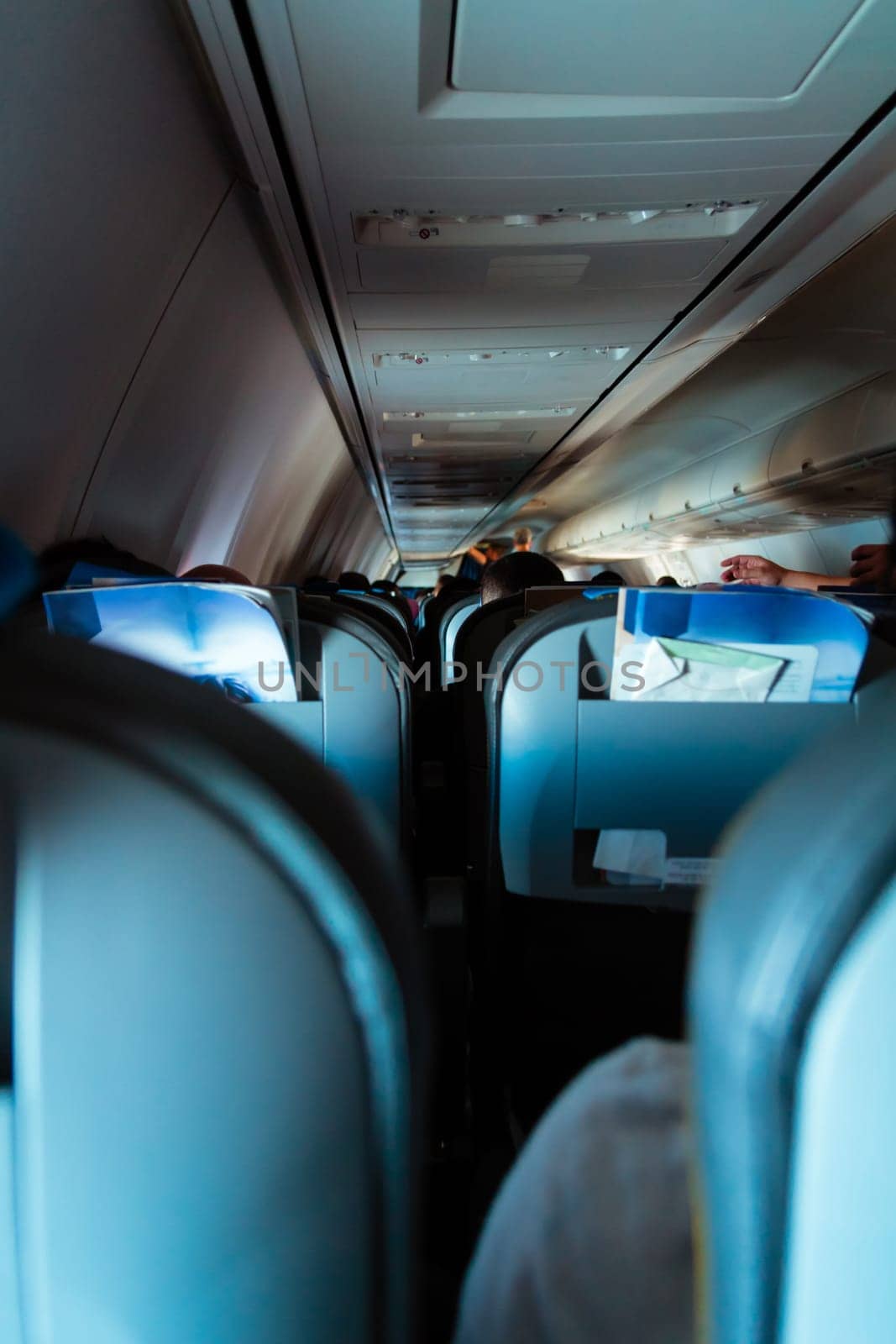 Interior of passenger airplane with people on seats.