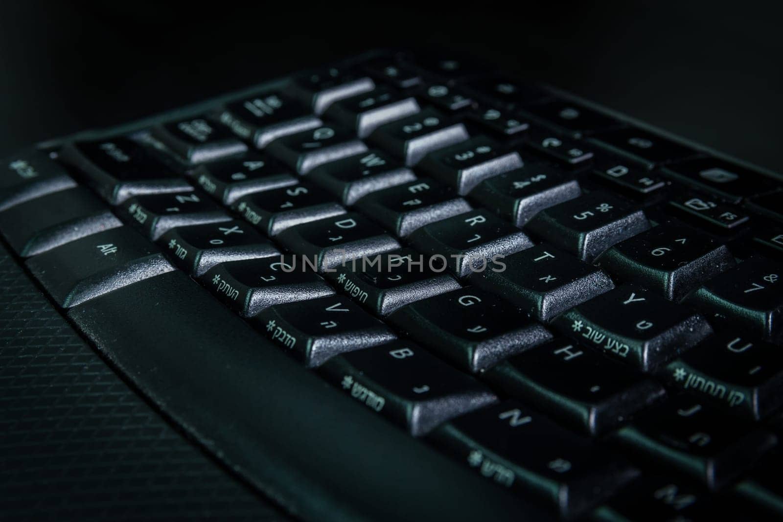 Keyboard with letters in Hebrew and English - Wireless keyboard - Close up - Dark atmosphere