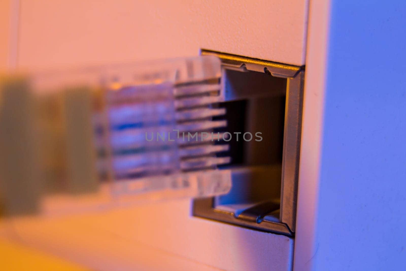 Macro close up of insert ethernet cable into WiFi extender device which is in electrical socket on the wall. The device is in access point mode that help to extend wireless network in home or office.