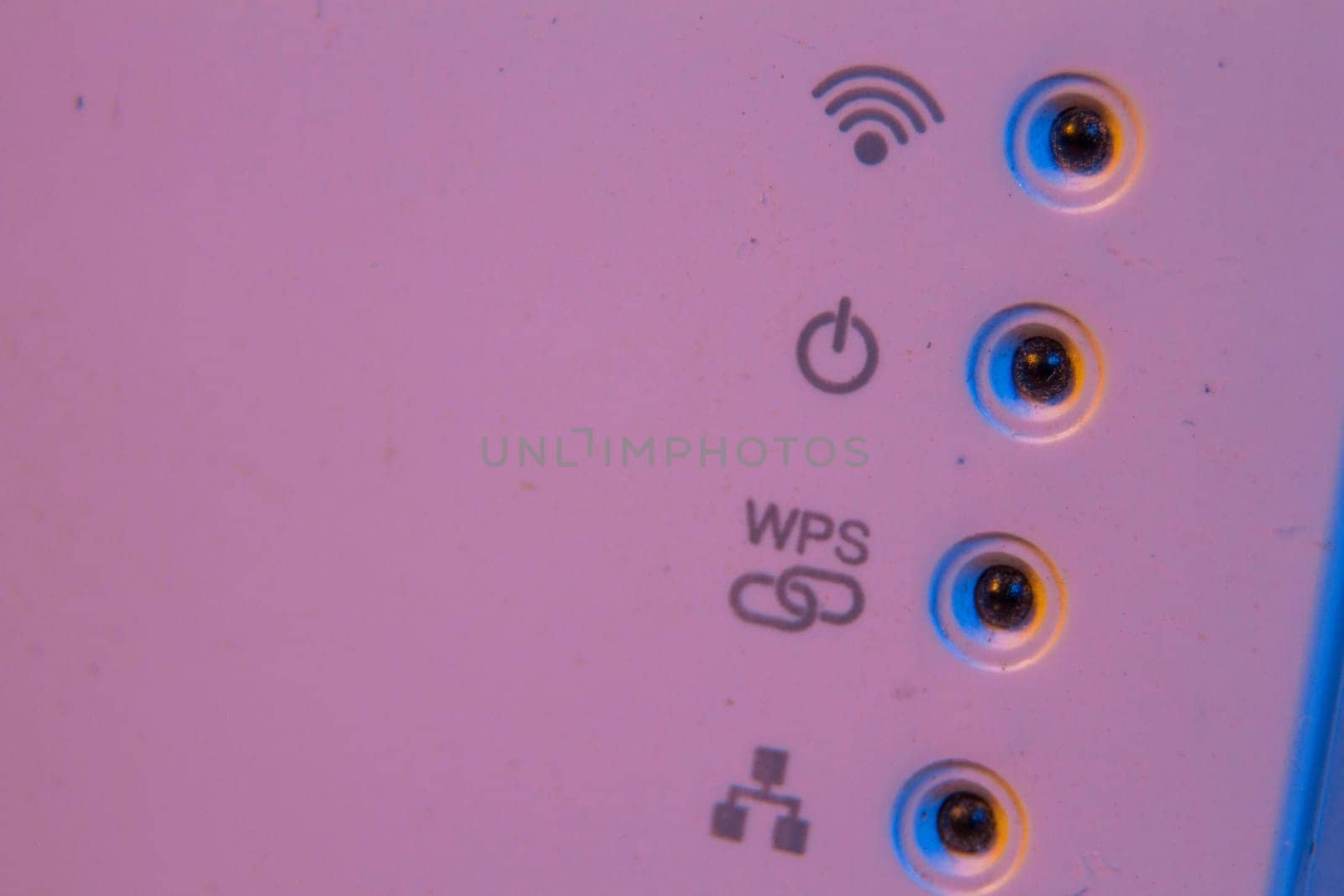 Macro closeup on WiFi repeater signal connection status led lights. The device is in electrical socket on the wall. It help to extend wireless network in home or office.