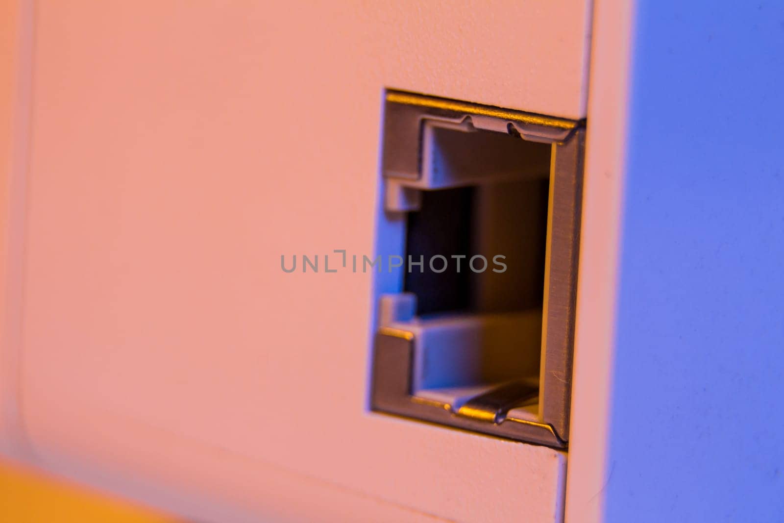 Macro closeup on WiFi repeater ethernet socket. The device is in electrical socket on the wall. It help to extend wireless network in home or office.