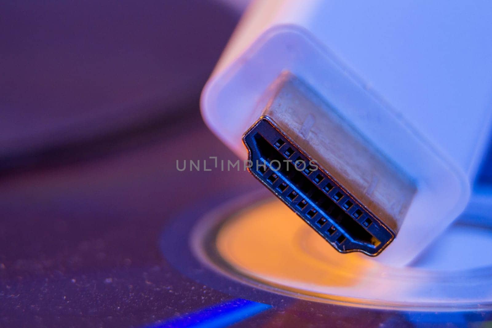 Closeup of white HDMI cable with it's reflection on blank disc.