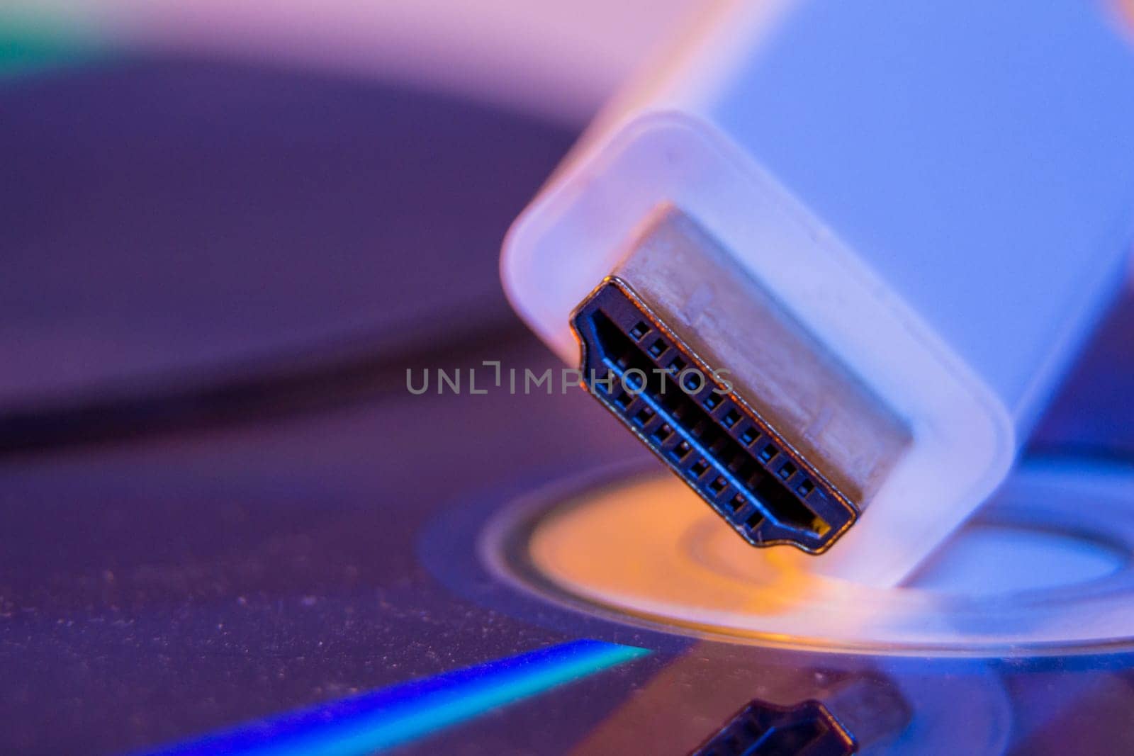 Closeup of white HDMI cable with it's reflection on blank disc.