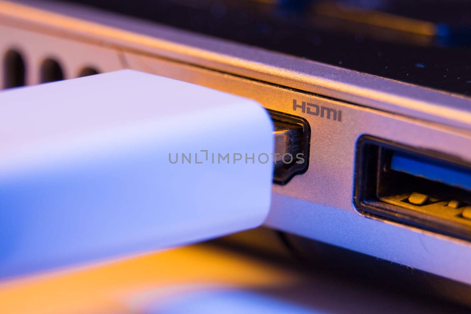 Closeup of HDMI cable plug inserted into port on the side of a laptop by wavemovies