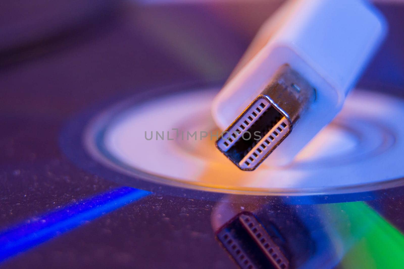 Closeup of white Mini Displayport cable with it's reflection on blank disc.