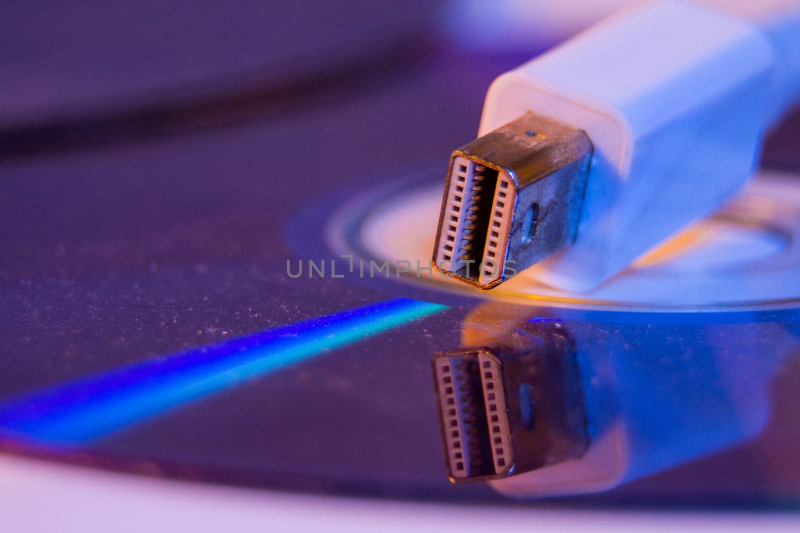 Closeup of white Mini Displayport cable with it's reflection on blank disc.