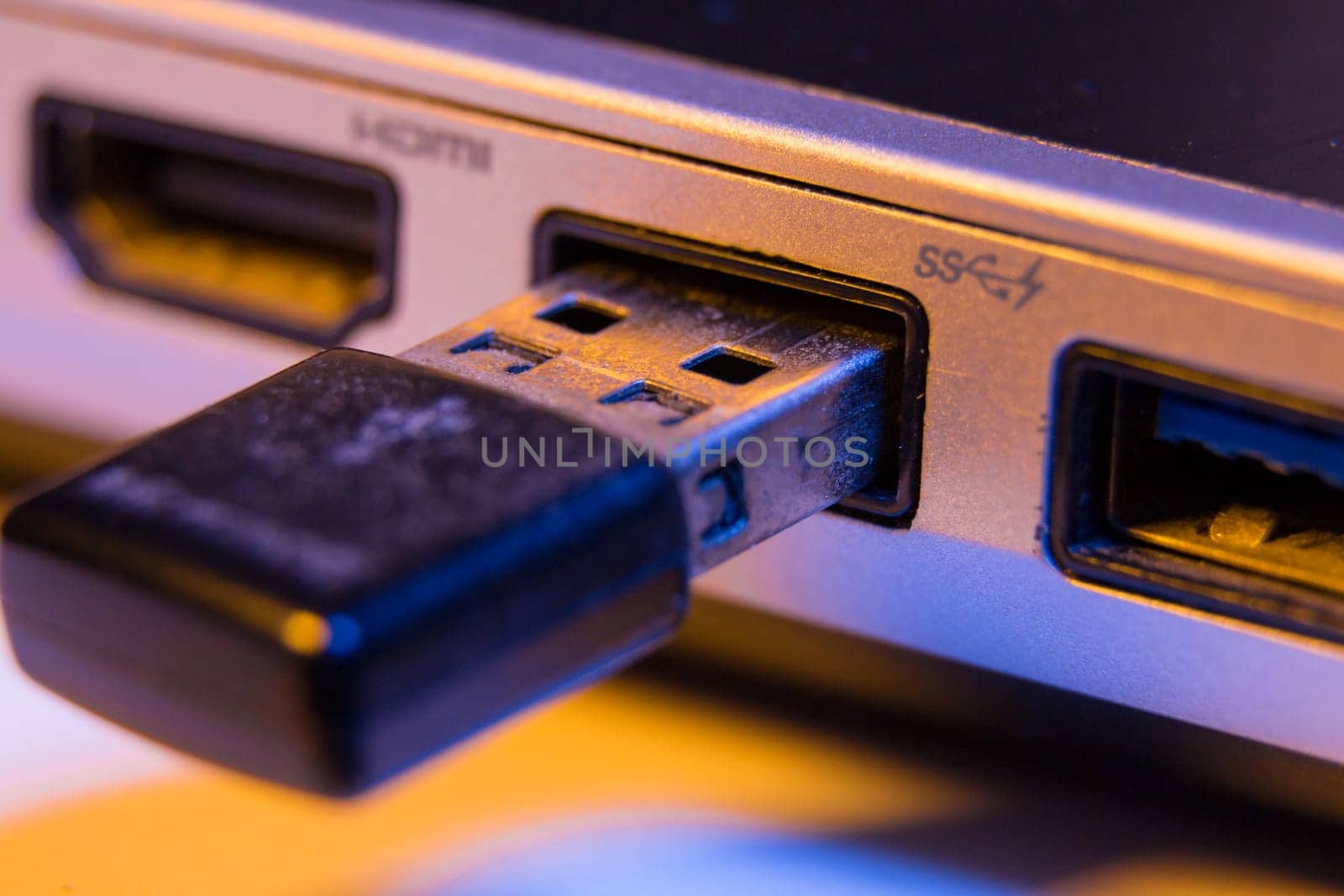 Closeup of USB flash drive inserted into port on the side of a laptop by wavemovies
