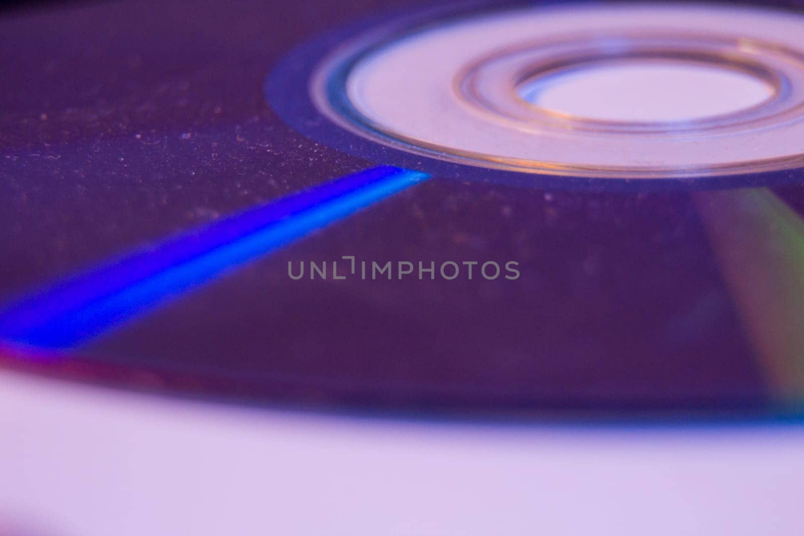 Macro closeup of Compact CD or DVD disc in violet color. by wavemovies