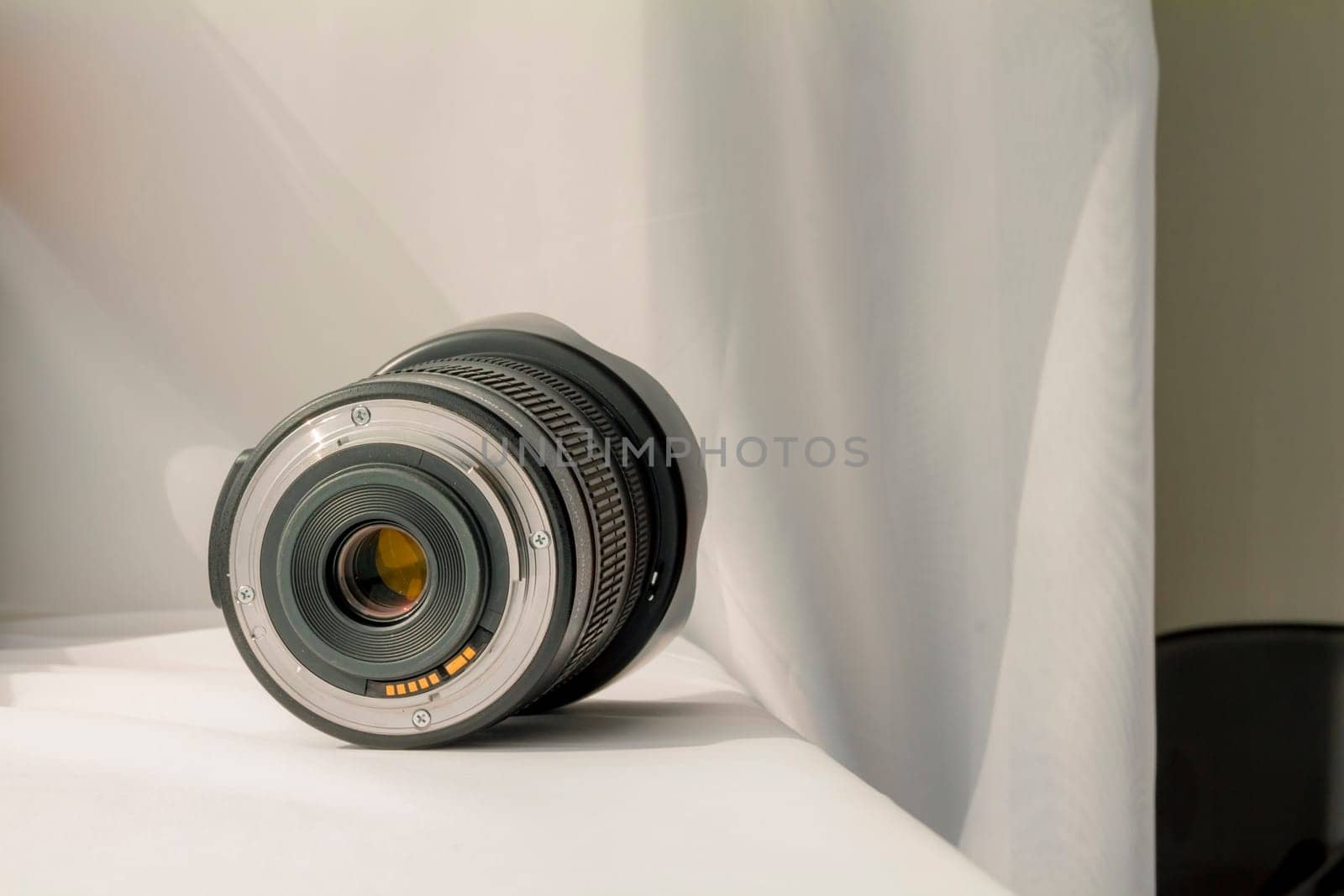 Black camera zoom lens on white cloth.