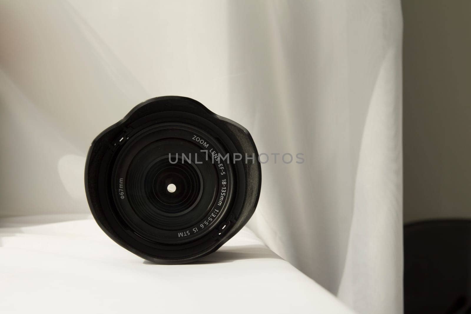 Black camera zoom lens on white cloth.