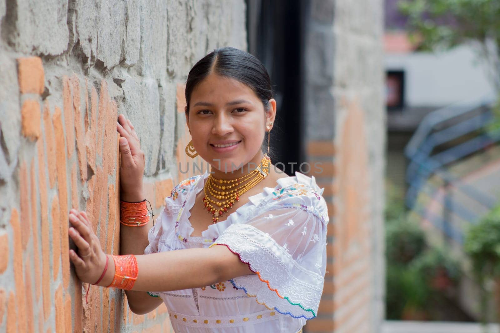 medium shot of empowered indigenous woman smiling and happy at camera in traditional dress by Raulmartin