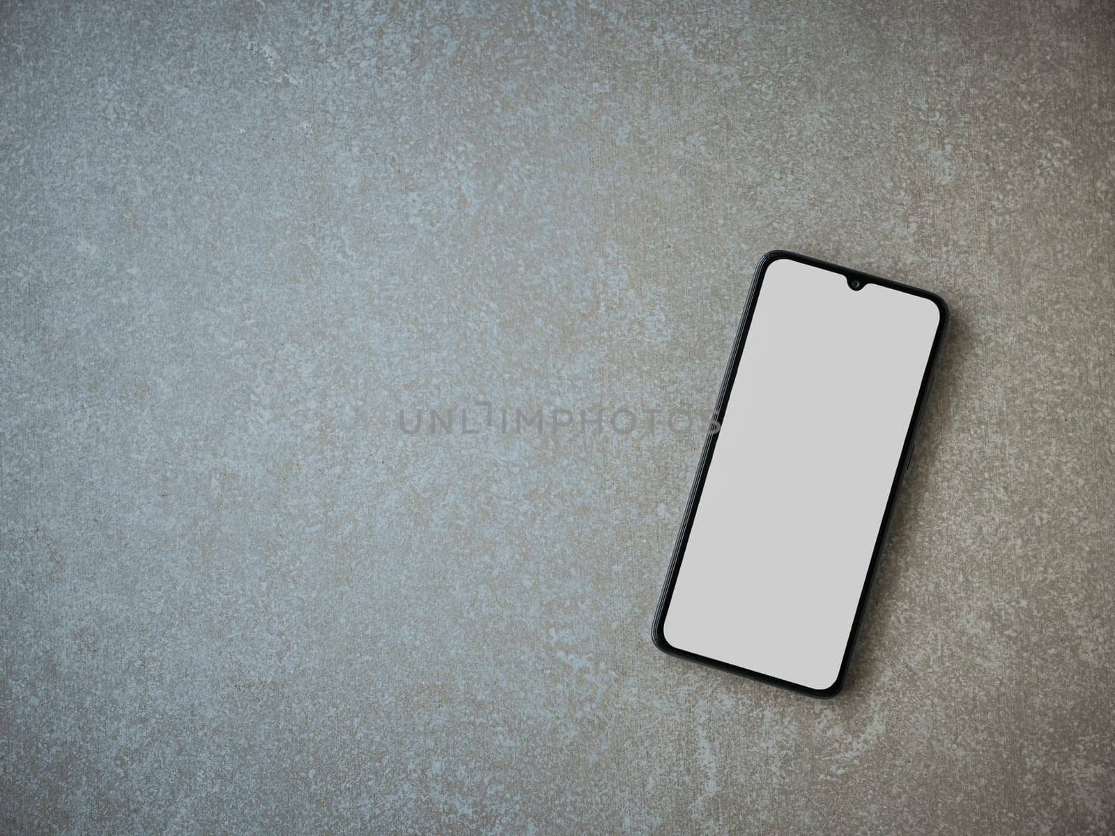 Black mobile smartphone mockup lies on the surface with a blank screen isolated on a porcelain granite ceramic stone background by wavemovies