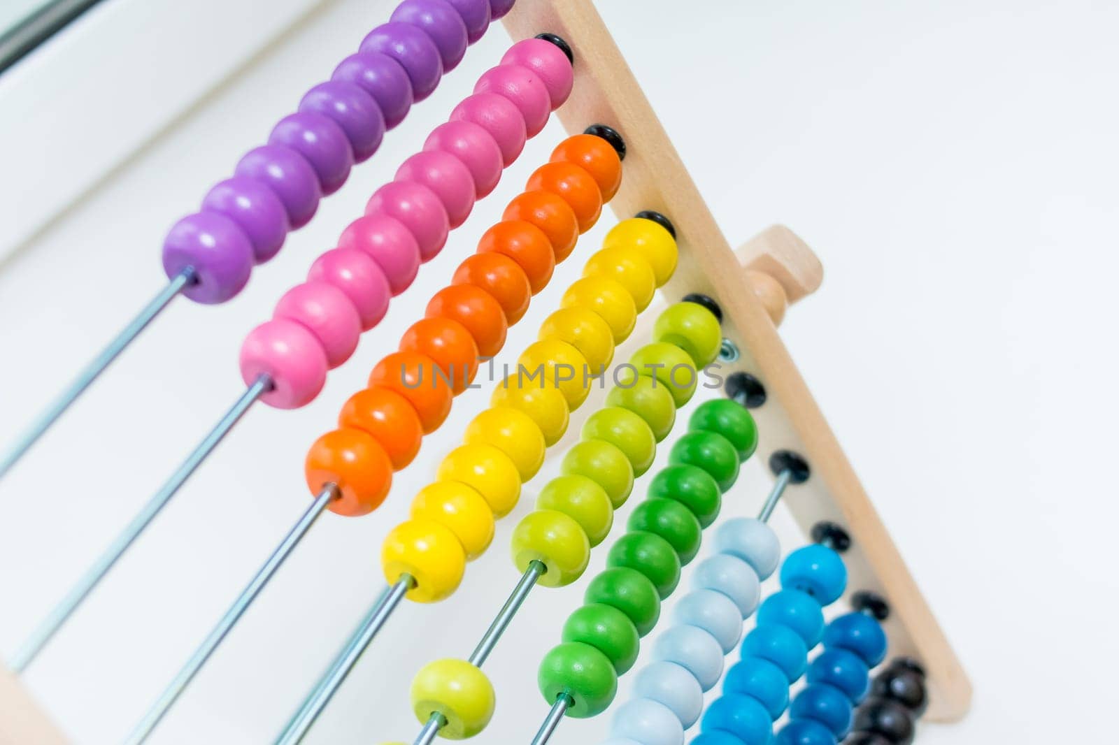 Preschooler baby learns to count. Cute child playing with abacus toy. Little boy having fun indoors at home, kindergarten or day care centre. Educational concept for preschool kids.