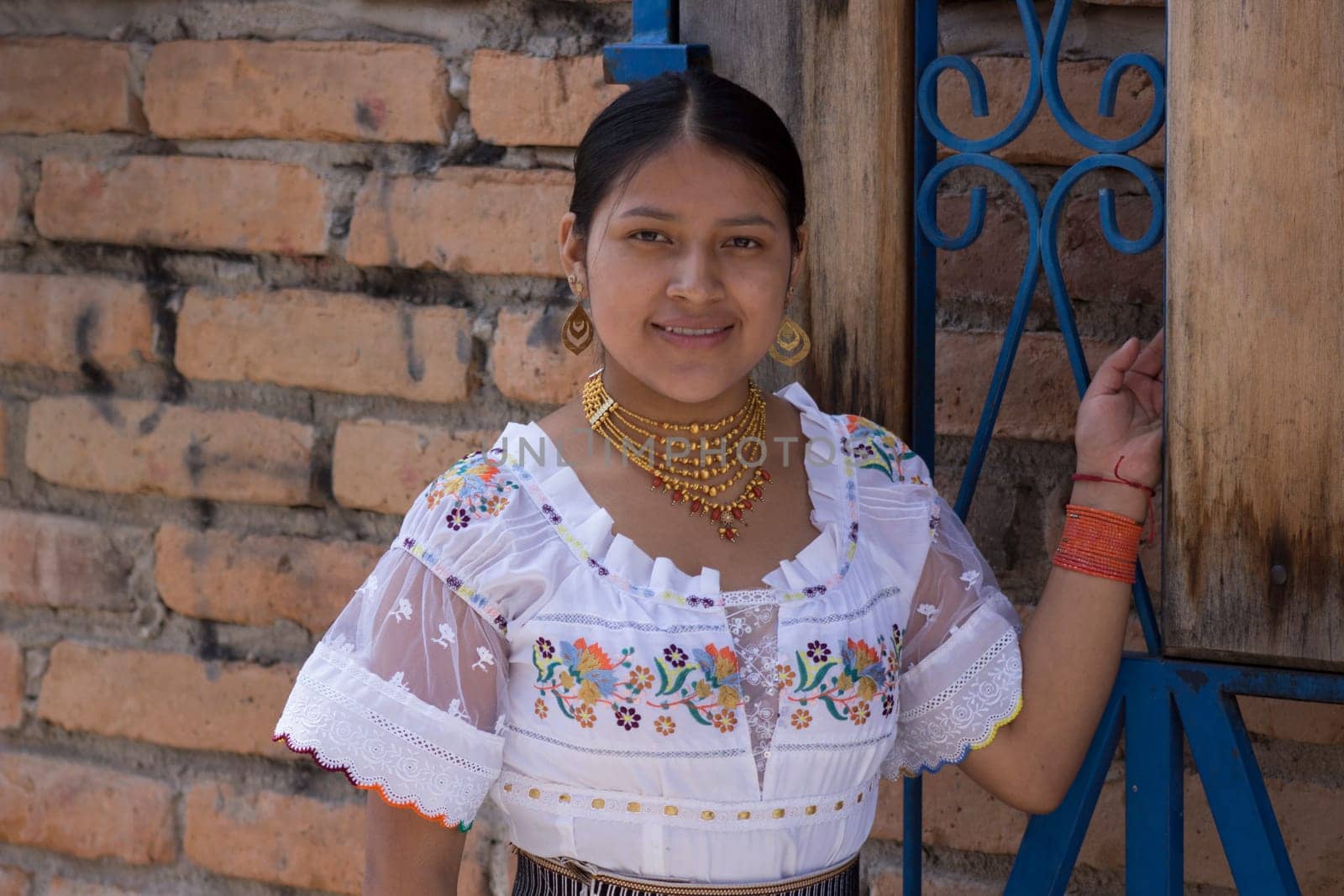 feminist indigenous woman in traditional dress on gay pride day looking at camera smiling and leaning on an iron gate. High quality photo