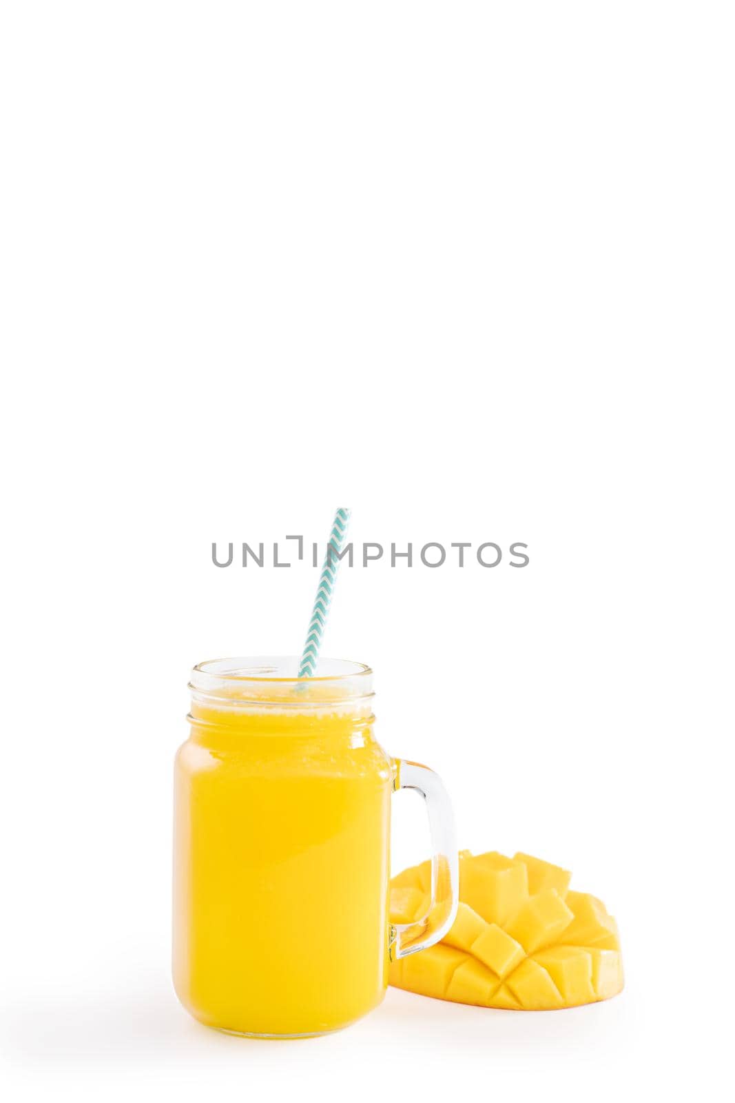 Fresh tropical mango juice with beautiful diced pulp and striped paper straw isolated on white background table, close up, cut out, clipping path.