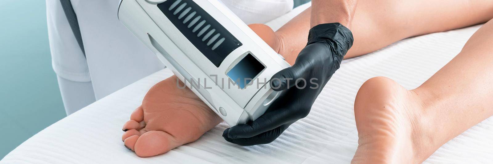 cosmetologist in rubber gloves doing endospheres therapy on female feet by Mariakray