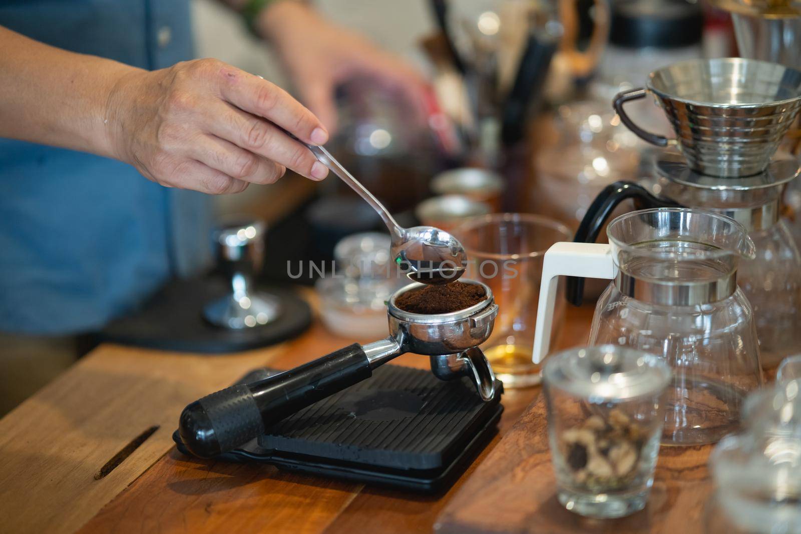 barista making hot coffee in the coffee shop by Wmpix