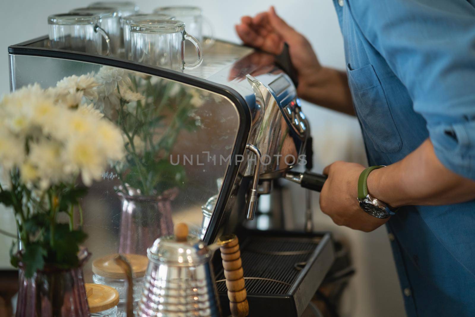 barista making hot coffee in the coffee shop by Wmpix