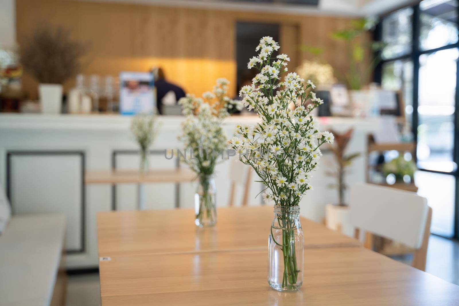 close up of white flowers on wood table in the cafe by Wmpix