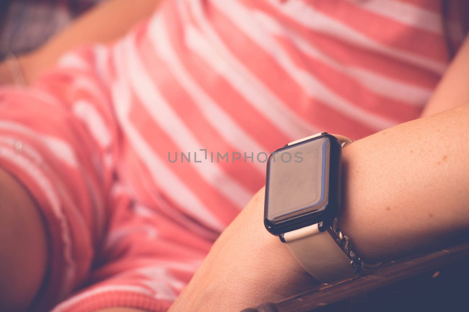 Smartwatch on sitting young woman hand. Close up, selective focus with copy space.