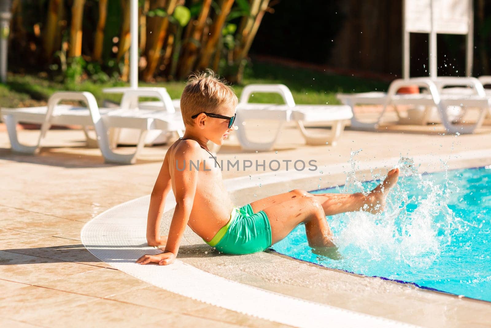 Happy little boy having fun at the pool at the resort. Summer holiday for kids concept