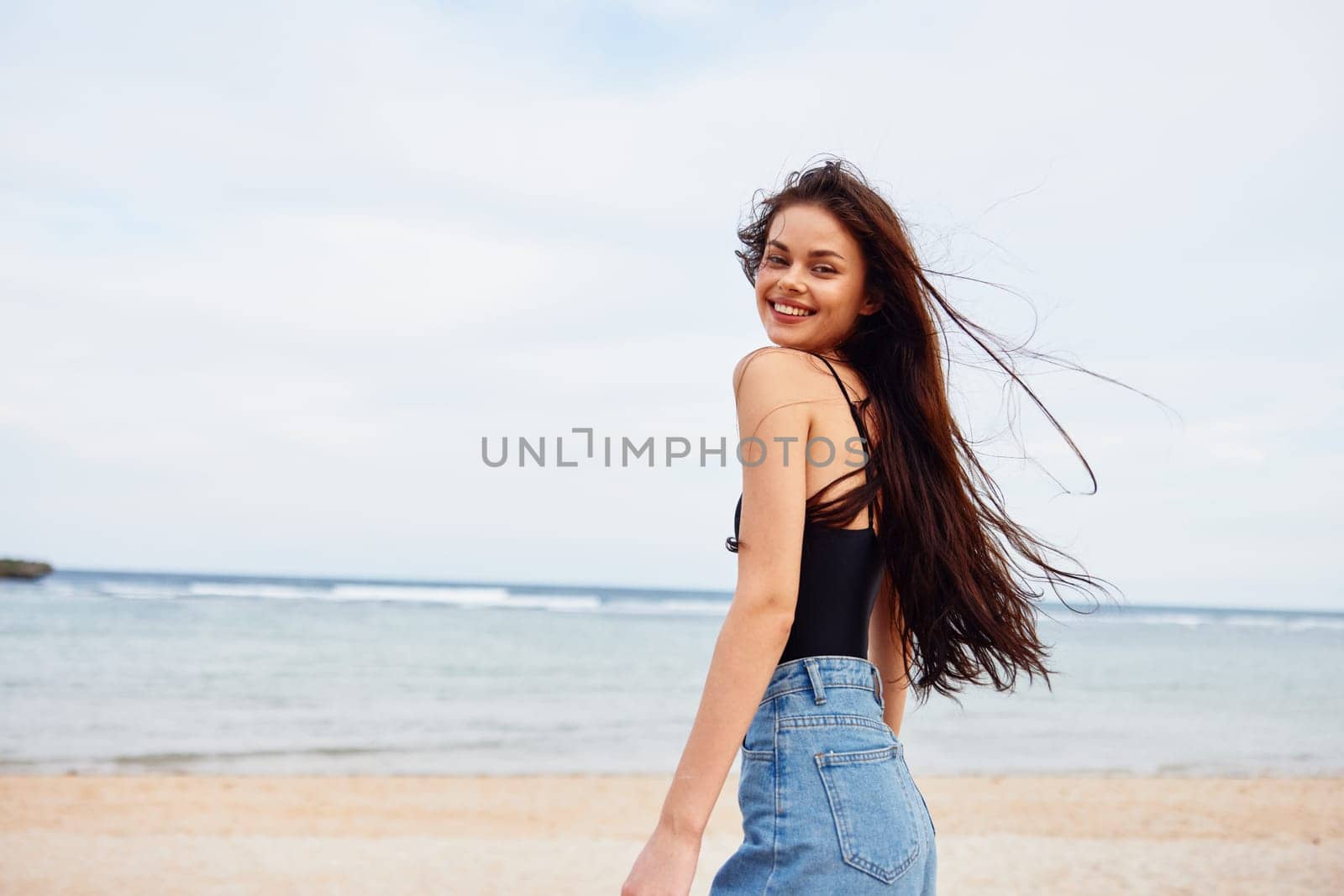 woman sky coast sea ocean summer outdoor young copy-space beach water sun vacation lifestyle sand running smile long hair nature enjoyment tropical