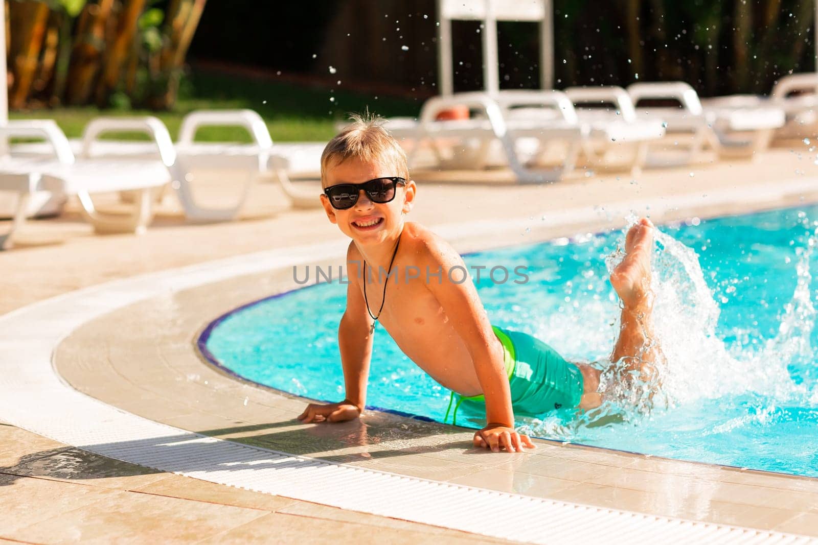 Happy little boy having fun at the pool at the resort by Len44ik