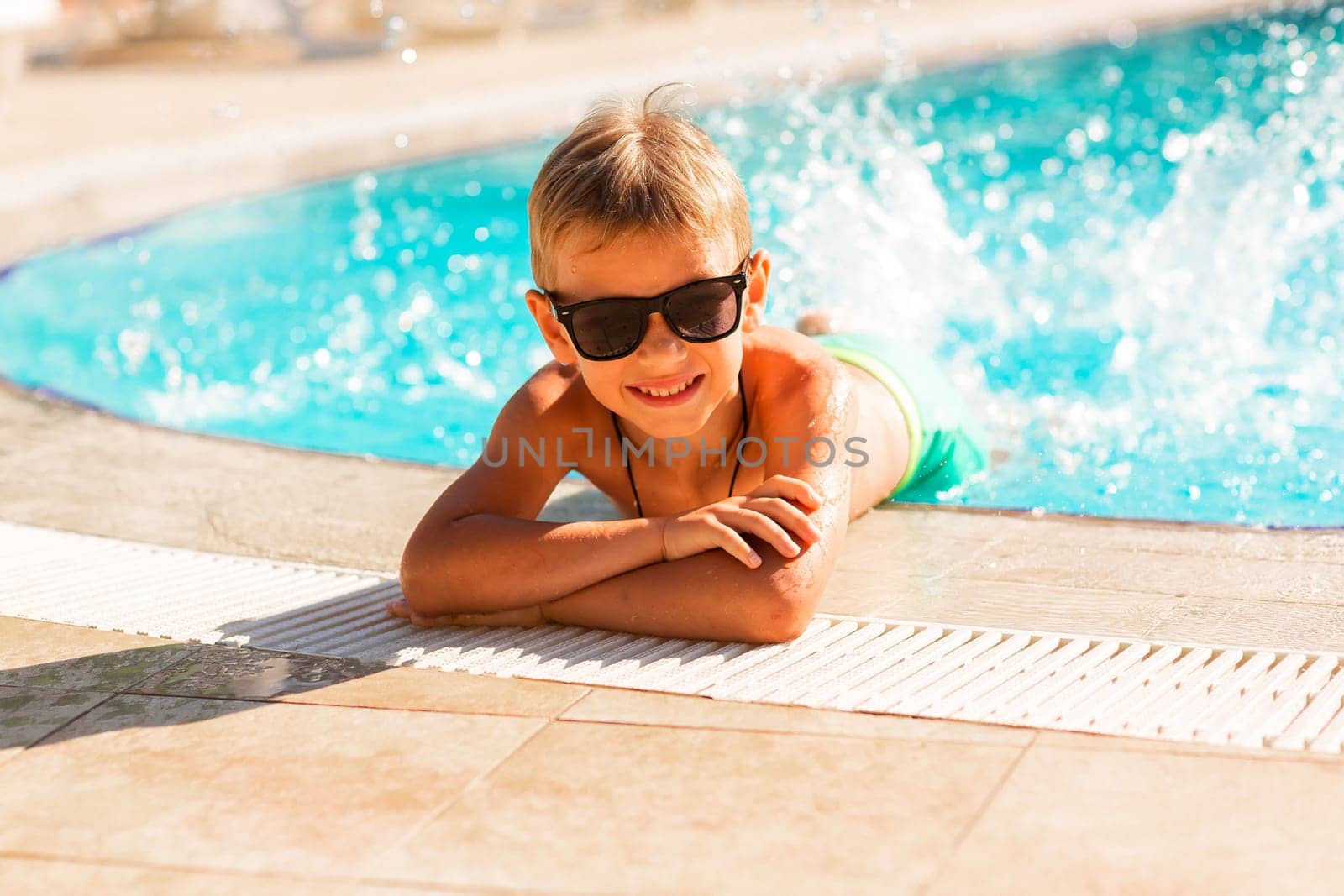 Happy little boy having fun at the pool at the resort by Len44ik