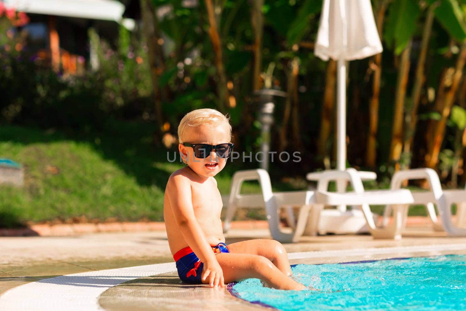 Happy little boy having fun at the pool at the resort by Len44ik