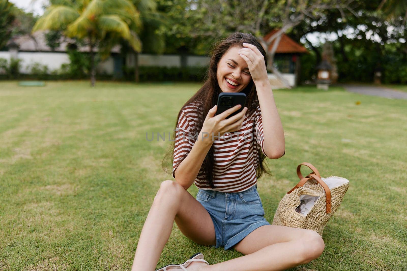 lifestyle woman outdoor smiling t-shirt girl palm caucasian human happy call cellphone walk phone nature smart grass blogger mobile park smartphone tree