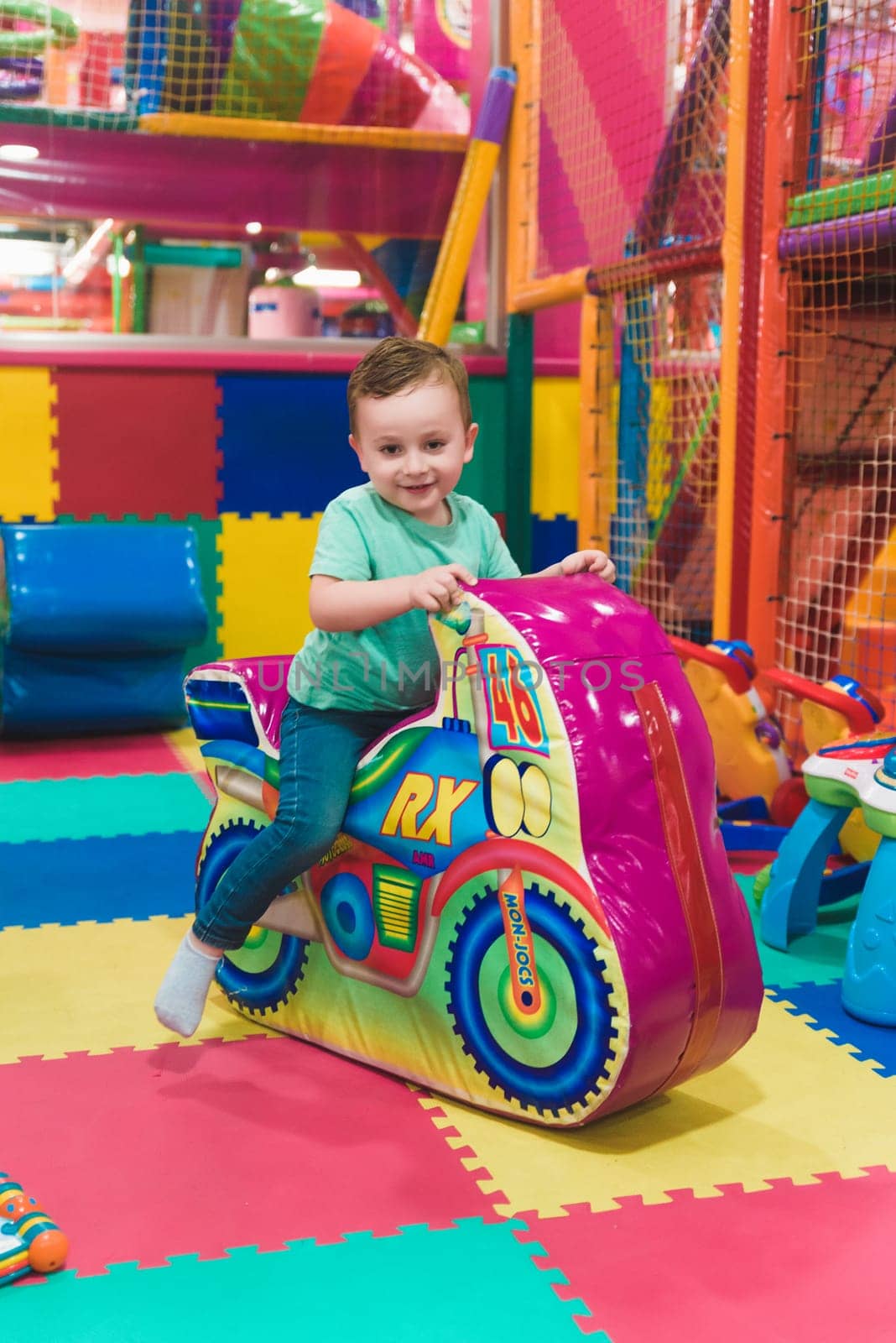 Child on the playground with colored plastic balls.