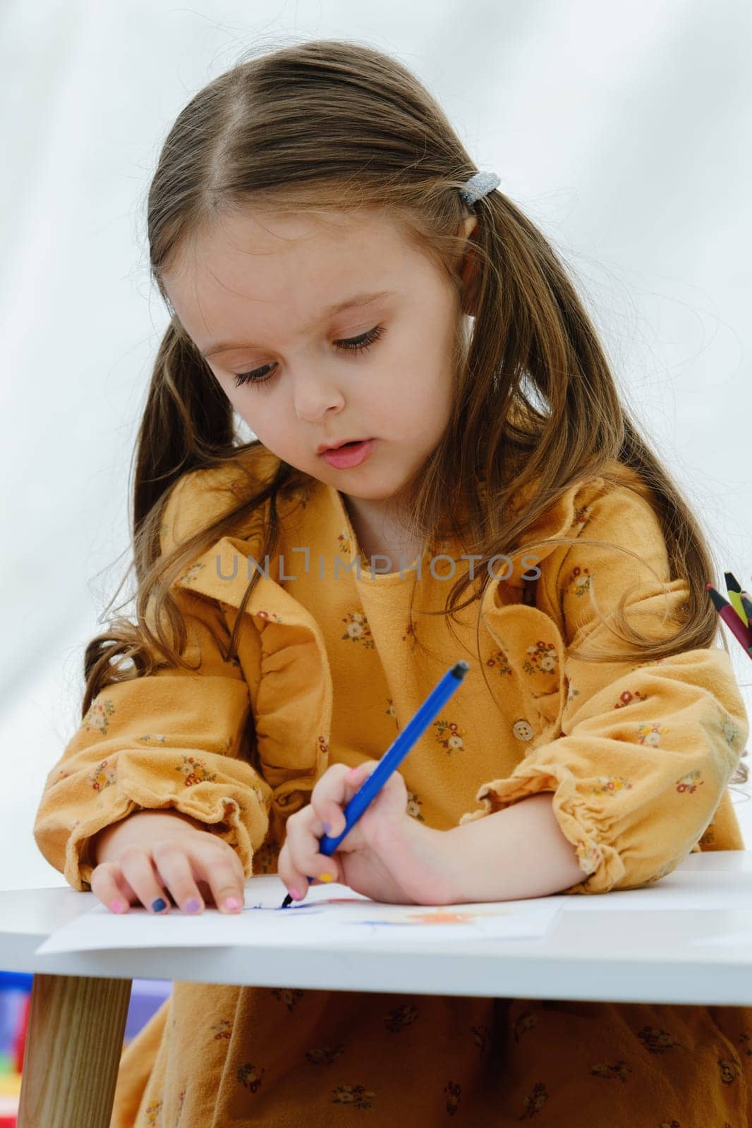 Portrait of a сute european kid girl painting with colored pencil. by leonik